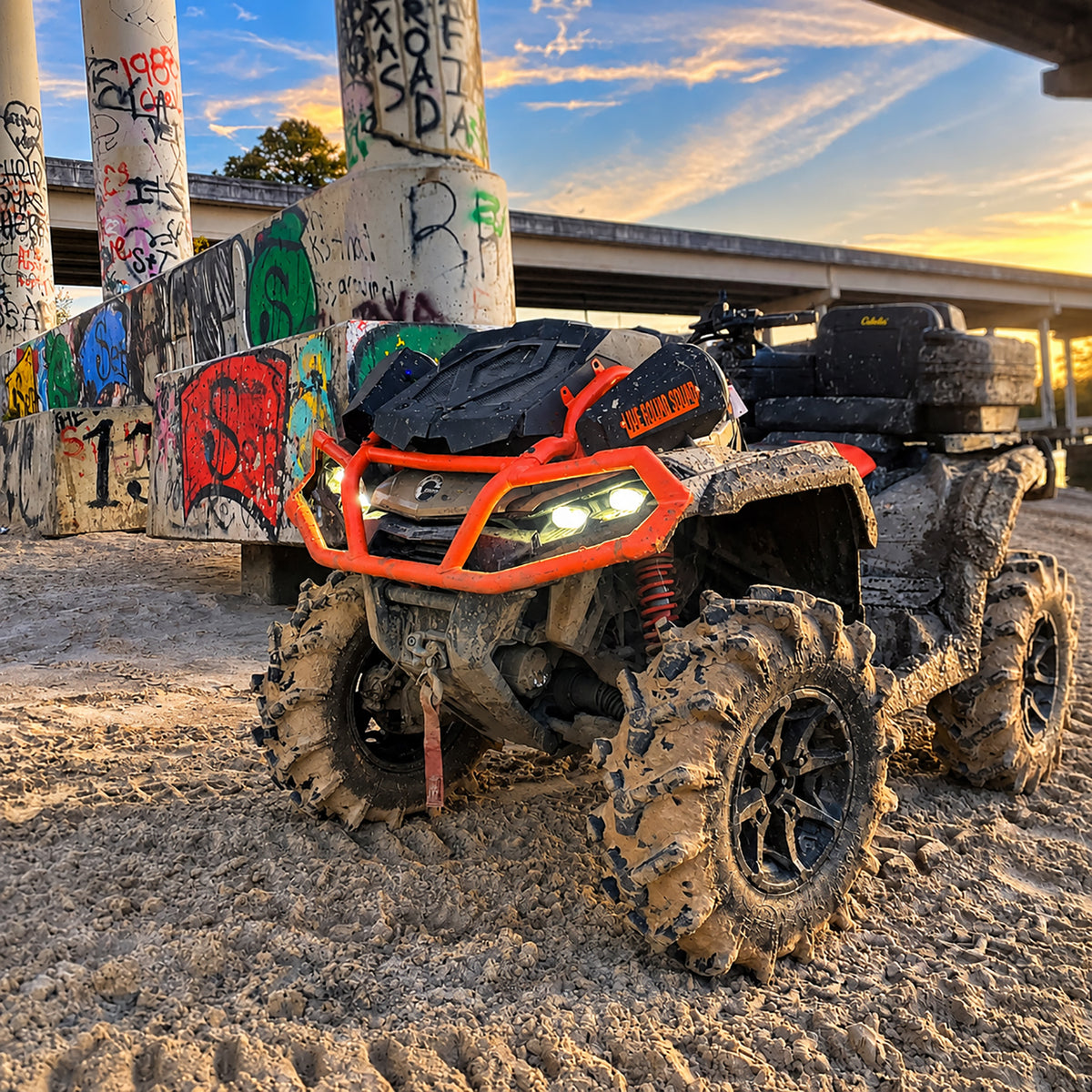 Lifted Can-Am Outlander X MR 1000R in muddy off-road conditions with PERFEX 2" lift kit and mud tires.