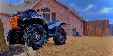ATV parked beside a house, showcasing a lift kit purchased from Perfex.
