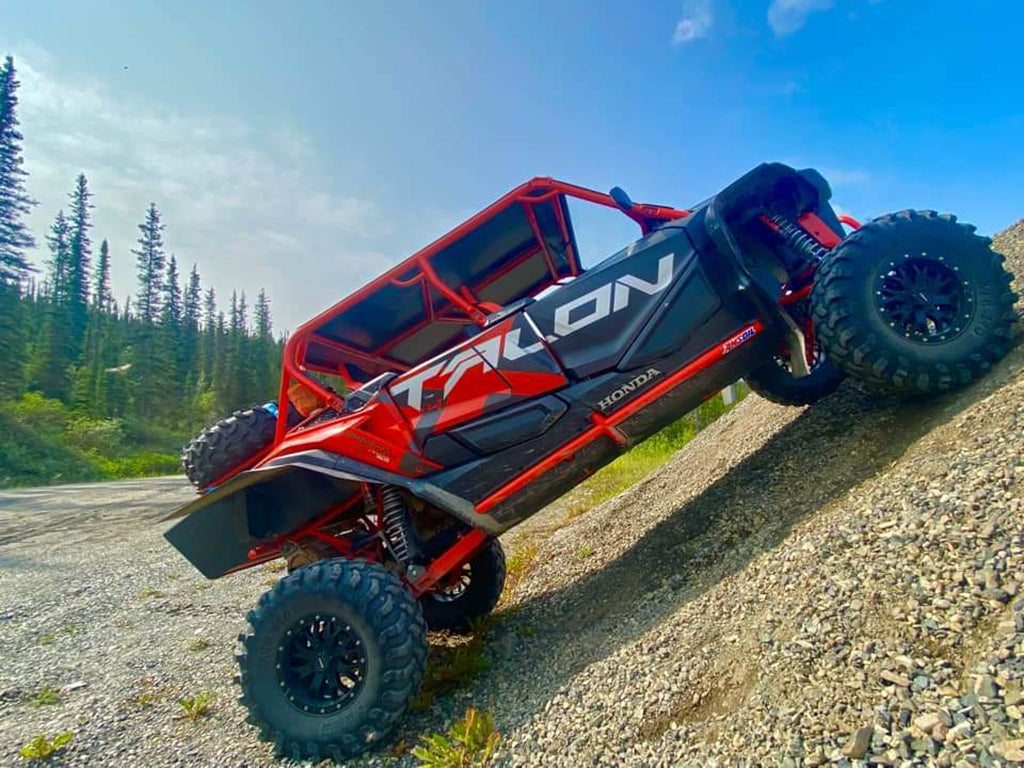 Red Honda Talon 1000 X-4 UTV showcased on a slope, demonstrating the 2-inch lift kit crafted by Perfex.