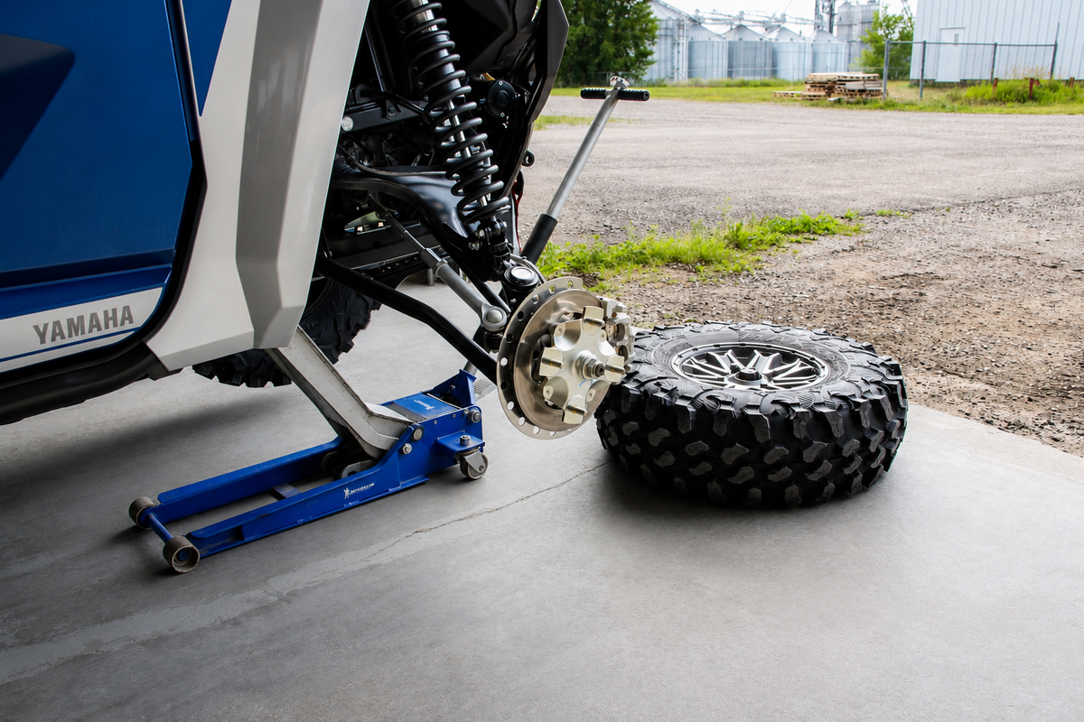 Removing the ATV or UTV wheel from the hub after safely lifting and supporting the vehicle for wheel spacer installation.