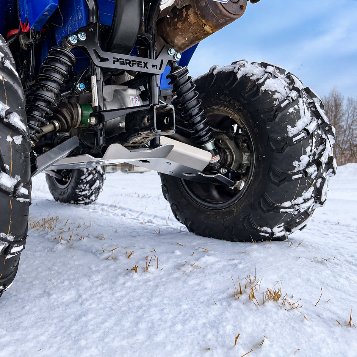 Close-up of the Yamaha Kodiak 450 rear suspension with the PERFEX lift bracket installed above the rear shocks as part of the 2-inch lift kit.
