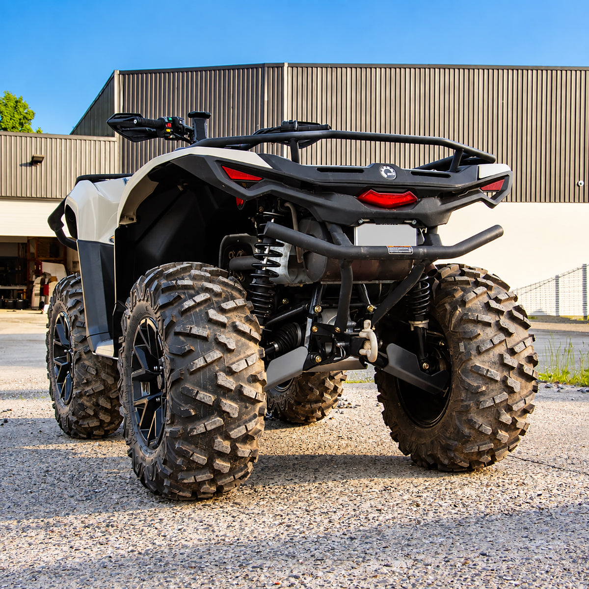 Rear three-quarter view of a Can-Am Outlander 700 PRO with PERFEX 1-inch lift kit, showing the rear suspension and lifted stance.