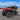 Orange CFMOTO CForce 500 HO ATV equipped with a PERFEX 1.5-inch lift kit, shown from a front three-quarter angle by the waterfront.