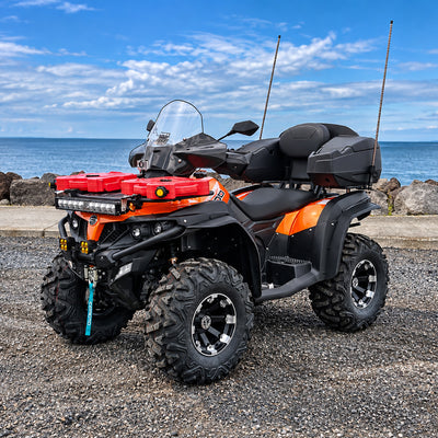 Orange CFMOTO CForce 500 HO ATV equipped with a PERFEX 1.5-inch lift kit, shown from a front three-quarter angle by the waterfront.