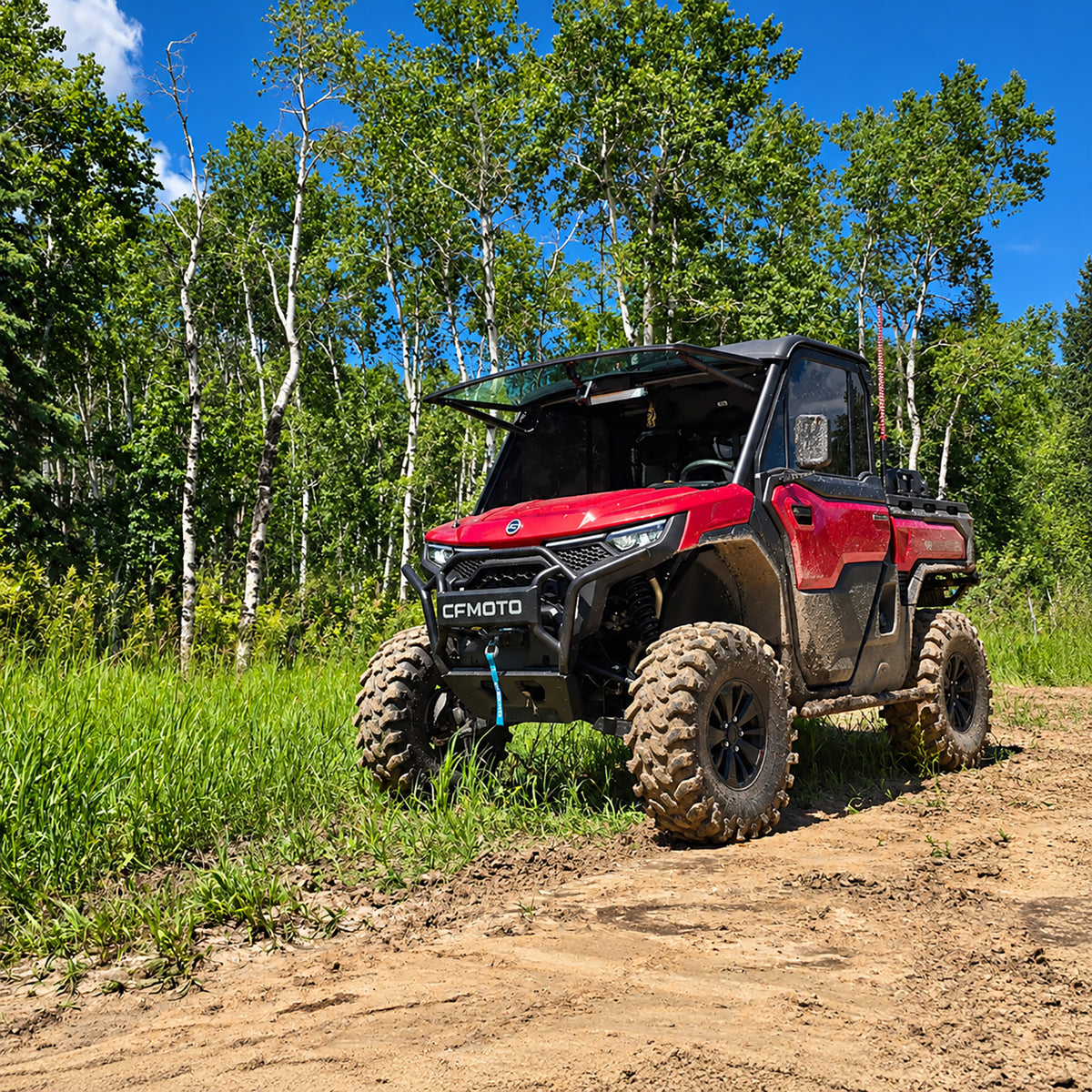 Red 2026 CFMOTO UForce U10 PRO Highland equipped with a PERFEX 2.5-inch suspension lift kit, showcasing increased ground clearance on a wooded off-road trail.