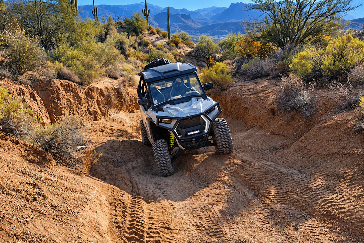 Polaris RZR Trail Sport with PERFEX 2-inch bracket lift kit driving through rugged off-road terrain.