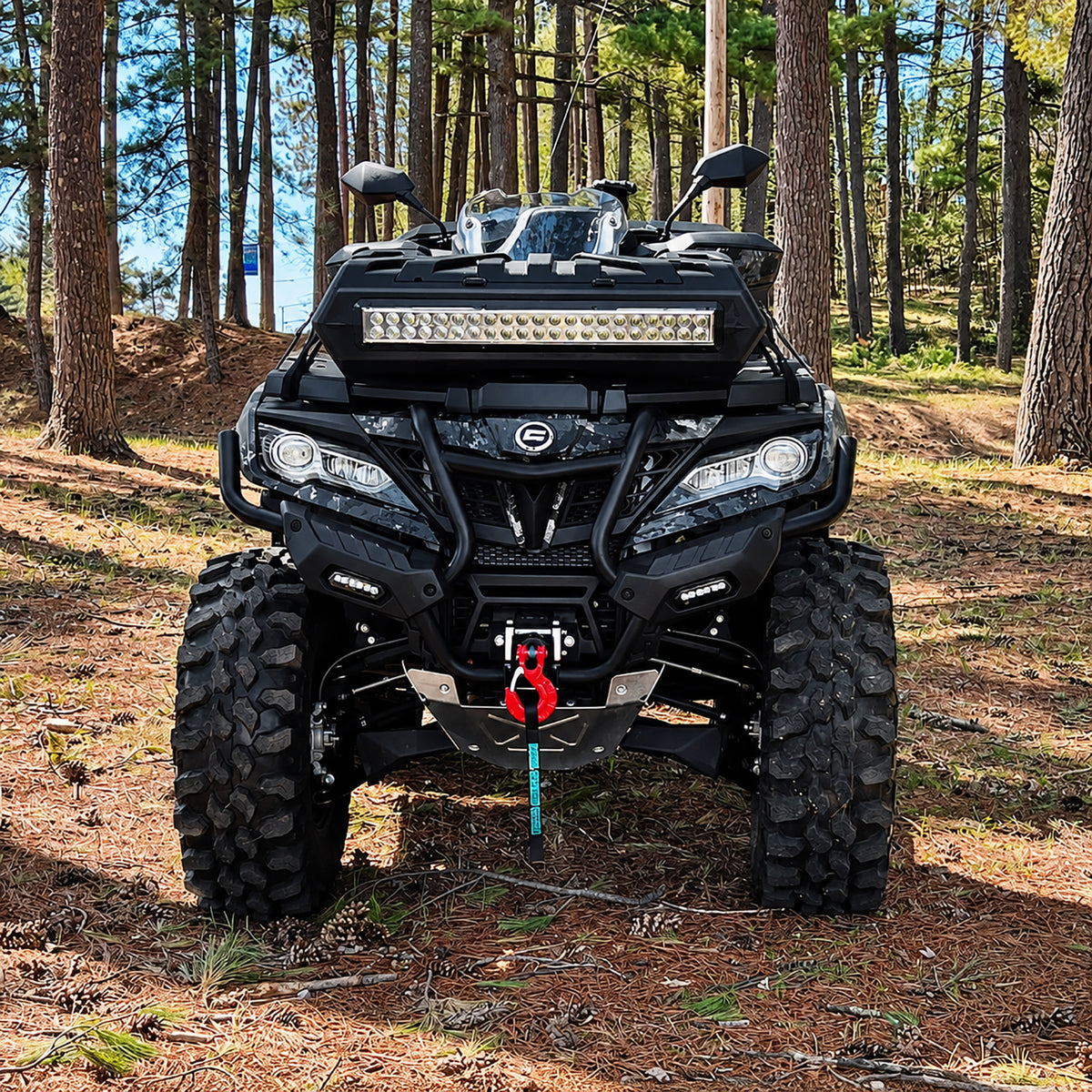 Front view of a CFMOTO CForce 1000 ATV with a PERFEX 2-inch lift kit and aggressive off-road tires in a wooded setting.