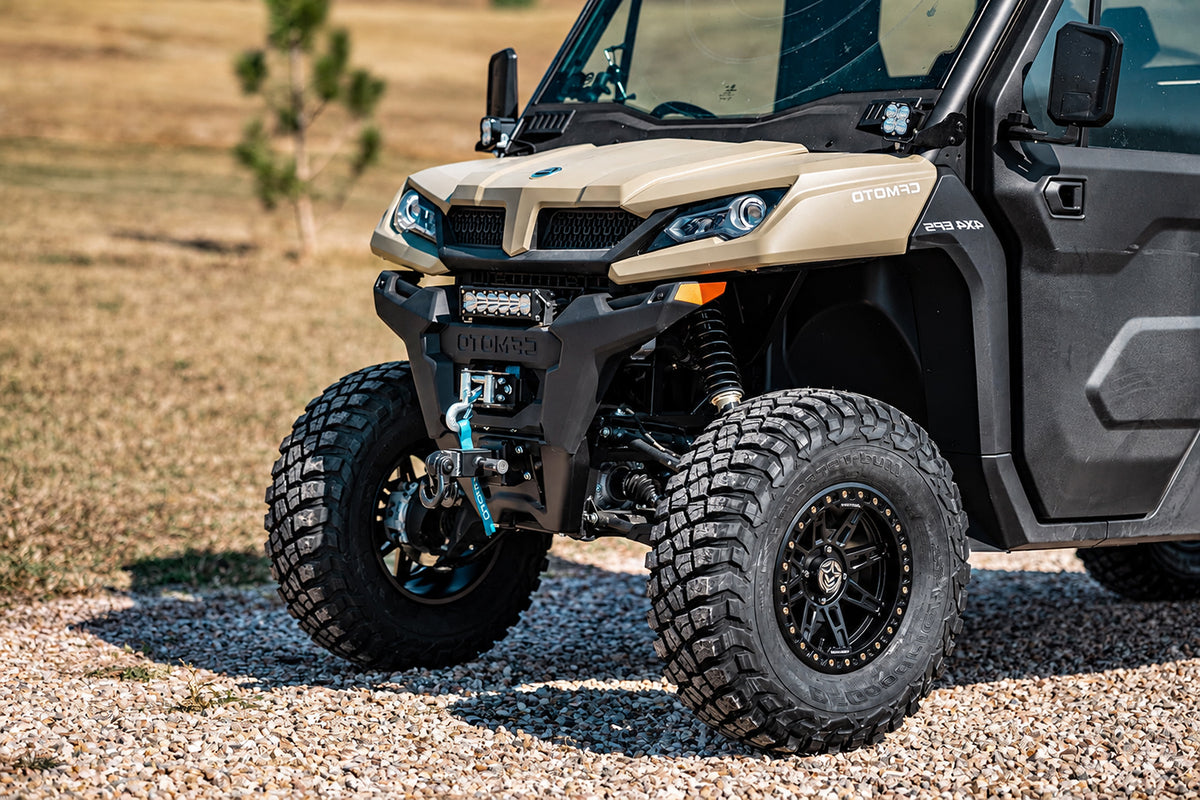 Close-up of the CFMOTO UForce 1000-XL front suspension and large all-terrain 30 inches tires with a PERFEX suspension lift installed.