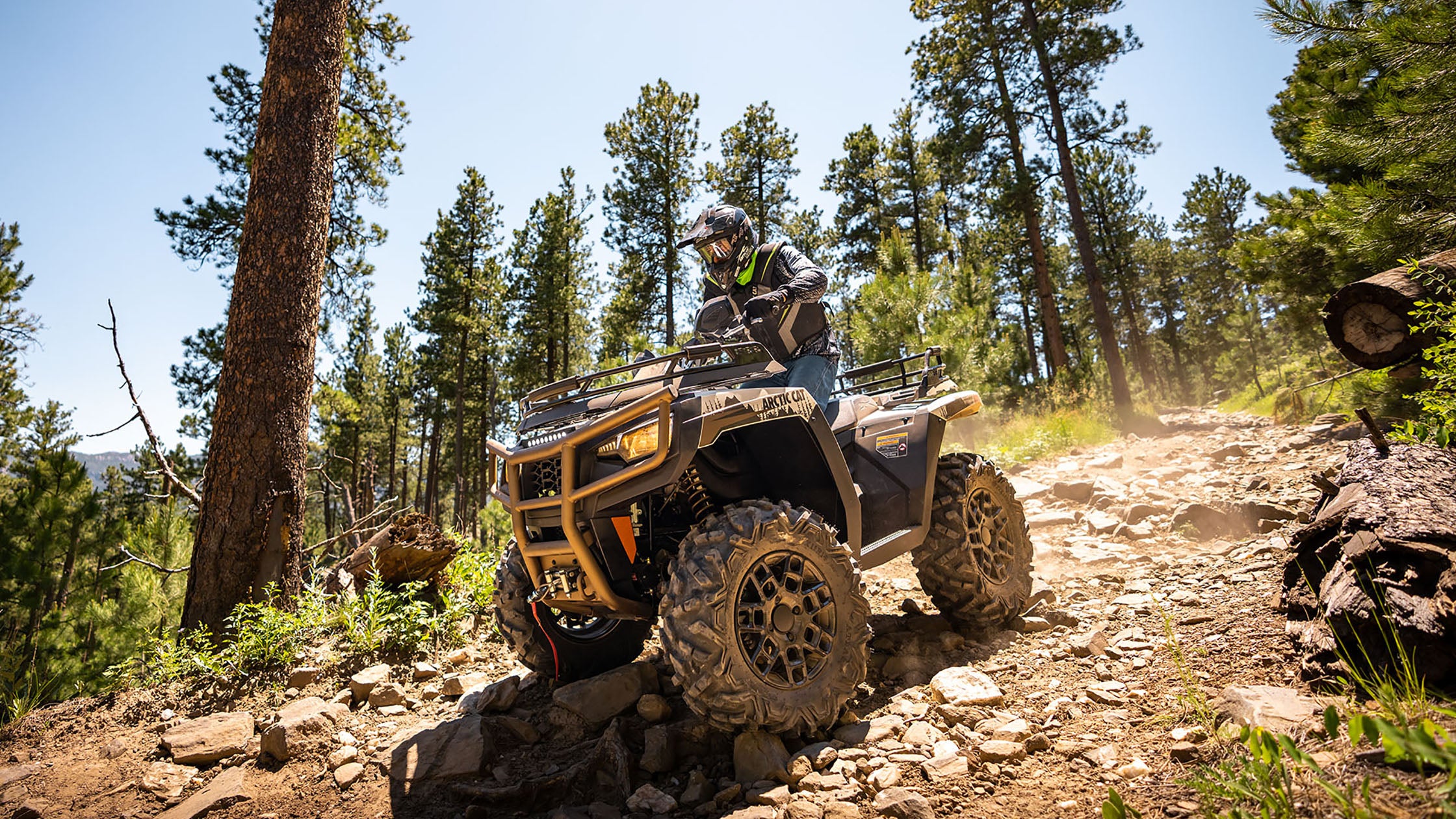 Arctic Cat ATV in action, speeding through nature with a PERFEX Industries lift kit, showcasing enhanced performance and rugged outdoor capability.
