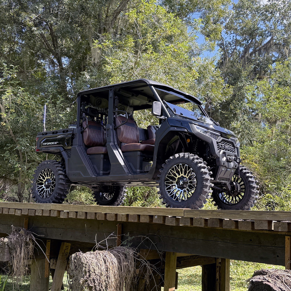 CFMoto UForce U10 XL PRO with PERFEX 2.5in lift kit, 33-inch System3 XT400 tires and 20-inch MSA wheels — photographed on a wooden bridge in Florida