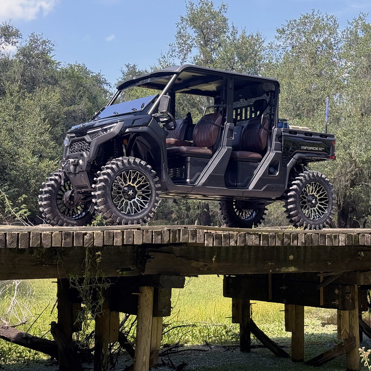 Side view of lifted CFMoto UForce U10 XL Pro with 2.5-inch PERFEX lift kit, 33in off-road tires and MSA 20” wheels, captured on a Florida wooden bridge