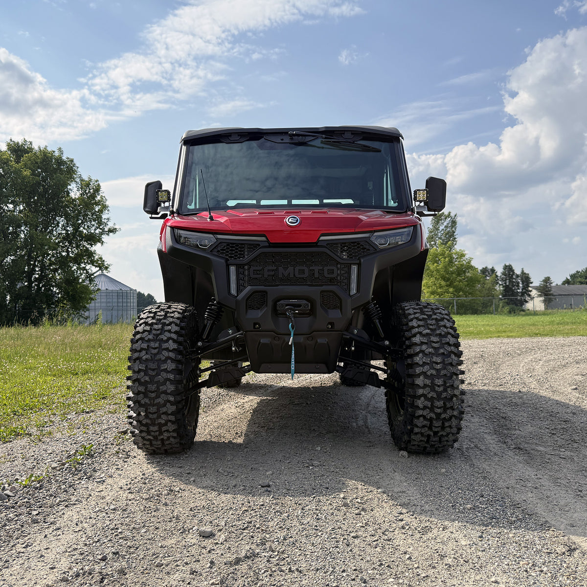 Front angle shot of lifted red CFMoto UForce U10 XL Pro Highland with 2.5-inch PERFEX lift kit and System3 RC500 tires — off-road ready with PERFEX mounting brackets installed