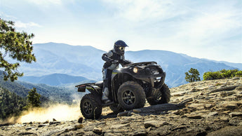 Kawasaki Brute Force 750 (ATV) equipped with a PERFEX Industries lift kit, engaging in off-road action, climbing a mountain terrain, showcasing its powerful performance and enhanced climbing abilities.