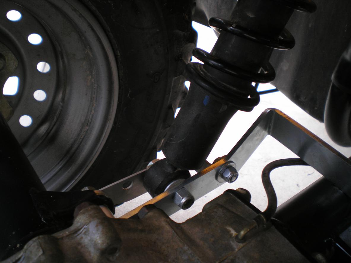 Close-up of the PERFEX suspension long travel kit installed on a Honda Foreman 500, illustrating the increased shock travel and ground clearance enhancements.