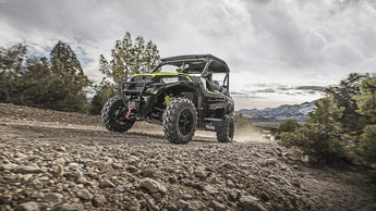 Polaris General 1000 (side-by-side) with a PERFEX Industries lift kit, navigating a rocky off-road trail, demonstrating its enhanced rugged capabilities and superior performance in challenging terrains.