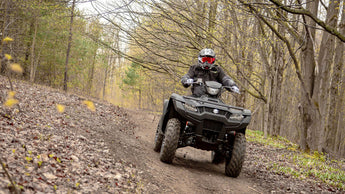 Suzuki King Quad with a PERFEX Industries lift kit, racing at full speed on a trail, showcasing its dynamic performance and the enhanced capabilities provided by the lift kit.
