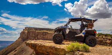 UTV featuring a Perfex lift kit, used on the 'Become a Dealer' page. The image shows the UTV atop a mountain.