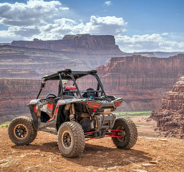 Polaris RZR 1000 XP atop a mountain for the 'Contact Us' page of the Perfex website.