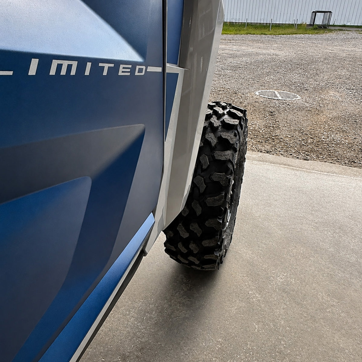 Checking front tire clearance on an ATV or UTV after wheel spacer installation before lowering the vehicle to the ground.