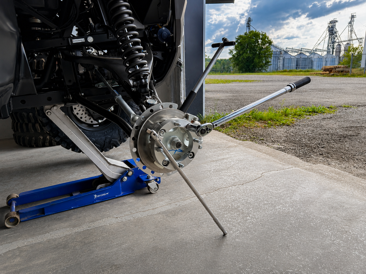 Torquing ATV or UTV wheel spacer nuts in a star pattern with a torque wrench while holding the hub with a breaker bar to prevent rotation.