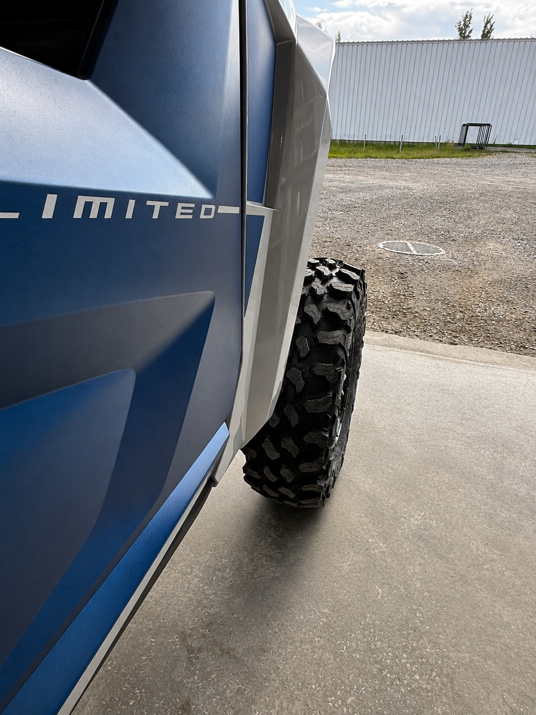 Checking front tire clearance on an ATV or UTV after wheel spacer installation before lowering the vehicle to the ground.